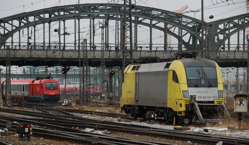 ES 64 U2-070 steht abgestellt im Vorfeld des Hbf M�nchen, w�hrend sich im Hintergrund der EC 113 auf den Weg nach �sterreich macht. Aufgenommen am 23.01.10.