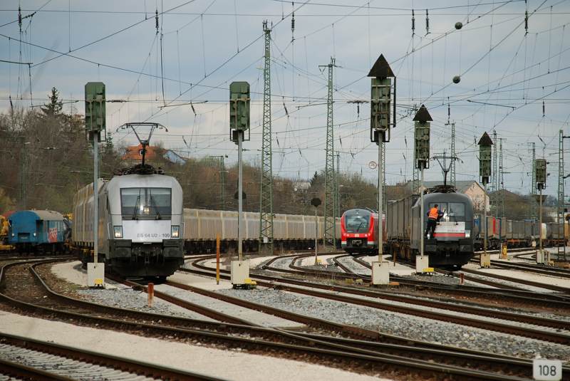 ES 64 U2-100, Hupac steht wartend am roten Signal. Der Lokf�hrer von ES 64 U2-098 nutzt die Wartezeit am roten Signal und schafft sich freie Sicht! Aufgenommen am 01.04.11, im Bahnhof Treuchtlingen.